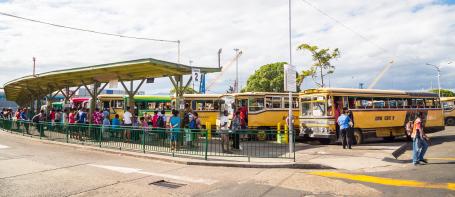 人们在一个车站等待登上斐济村庄之间的当地公共汽车