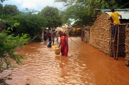 在肯尼亚北部加里萨，流离失所的肯尼亚人带着他们的物品穿过洪水泛滥的塔纳河。