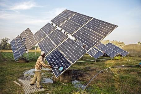 在印度哈里亚纳邦Jagadhri，农民Gurinder Singh的农场里，农场工人正在清洁太阳能水泵的太阳能电池板。图片来自Prashanth Vishwanathan (IWMI)