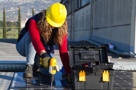 一名妇女在安装屋顶太阳能电池板。