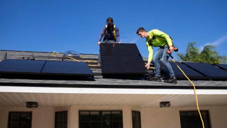 工人们在住宅屋顶安装太阳能电池板