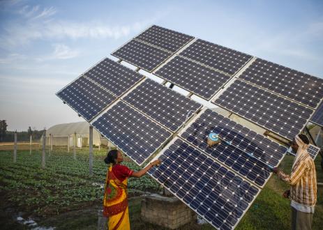 农场工人清洁的太阳能电池板,太阳能水泵在共和辛格的农场的农民土地持有Jagadhri 80英亩。