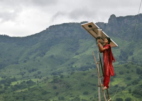 Meenakshi Dewan倾向于在她的印度Tinginaput村的太阳能街照明上进行维护工作。巨大的塔横跨这些山丘，为大城市供电，但这样的农村地区与主要网格没有连接。