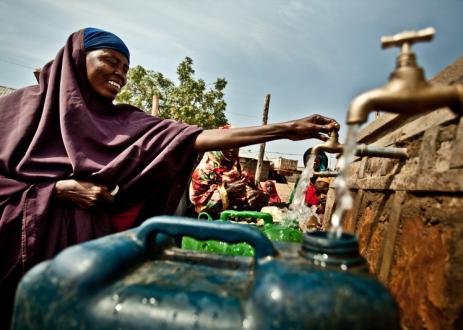 Habiba Hossen is collecting water from a rehabilitated distribution point in Kole Community.