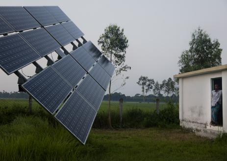 农村景观中的人看太阳能电池板